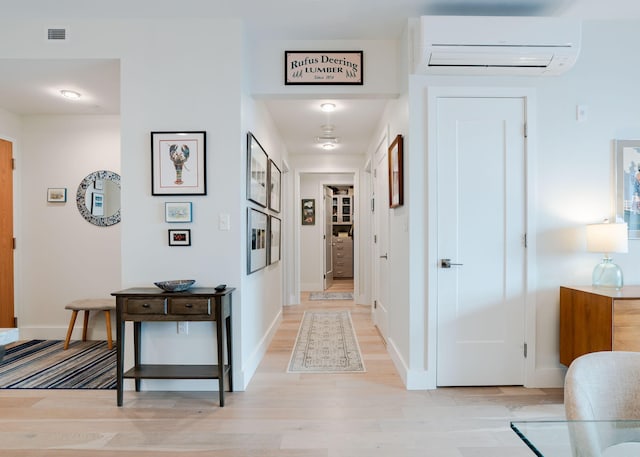 corridor featuring a wall mounted air conditioner and light wood-type flooring