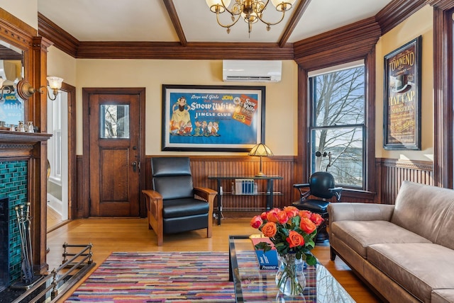 living room featuring an AC wall unit, wood walls, a notable chandelier, light hardwood / wood-style flooring, and crown molding