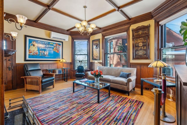 living area with light wood-type flooring, beam ceiling, a wall mounted air conditioner, a notable chandelier, and coffered ceiling