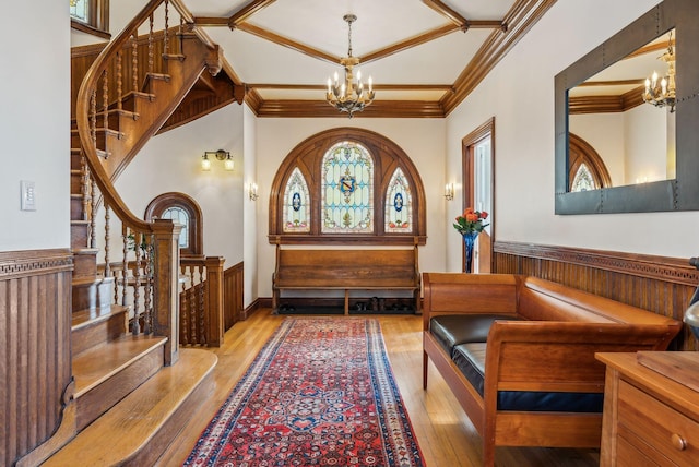 interior space featuring light hardwood / wood-style floors, ornamental molding, and a notable chandelier