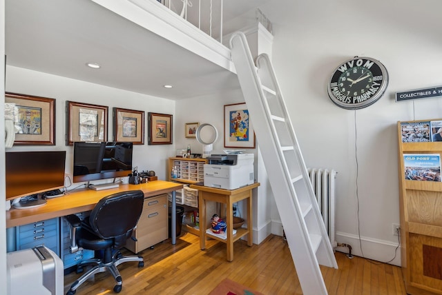 office with light wood-type flooring and radiator heating unit