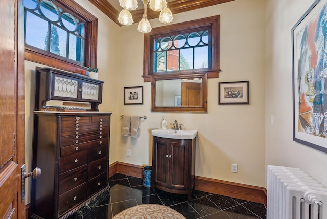 bathroom with ornamental molding, radiator heating unit, an inviting chandelier, and vanity