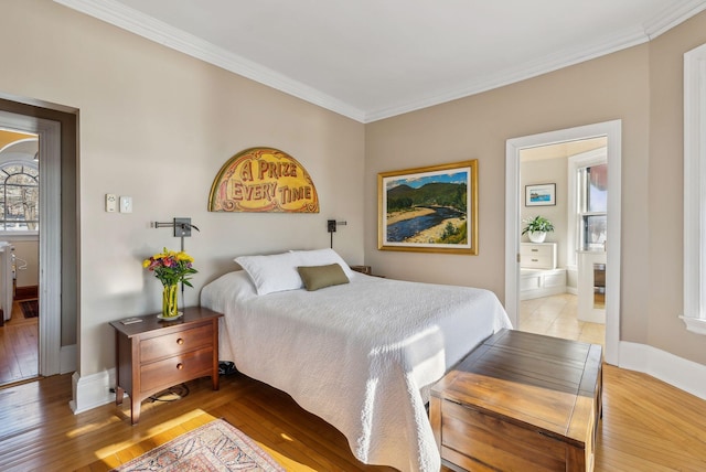 bedroom featuring ornamental molding, ensuite bathroom, and light hardwood / wood-style flooring