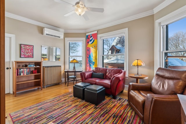 sitting room with an AC wall unit, a wealth of natural light, hardwood / wood-style flooring, and radiator heating unit