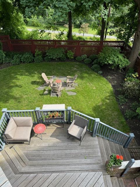 wooden terrace with a yard and a fire pit