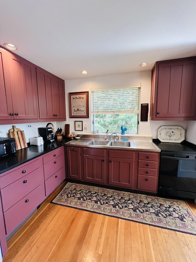 kitchen featuring sink, black appliances, and light hardwood / wood-style flooring