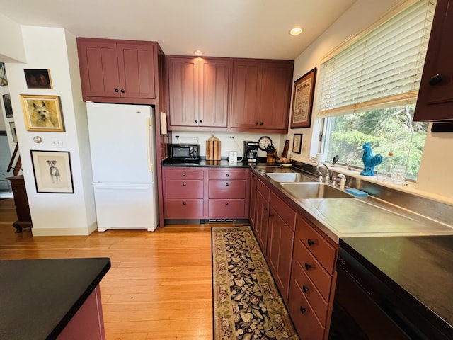 kitchen featuring sink, black appliances, and light wood-type flooring