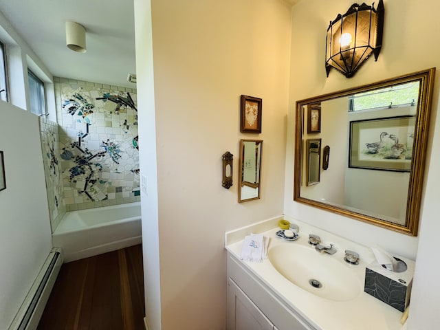 bathroom with a healthy amount of sunlight, vanity, tiled shower / bath combo, and a baseboard heating unit