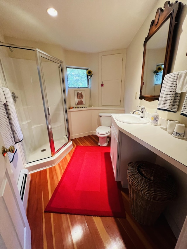 bathroom with hardwood / wood-style floors, vanity, a baseboard heating unit, toilet, and an enclosed shower