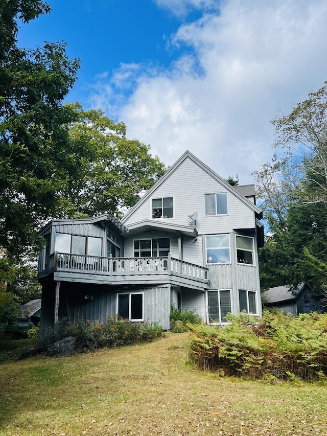 back of property featuring a yard and a wooden deck