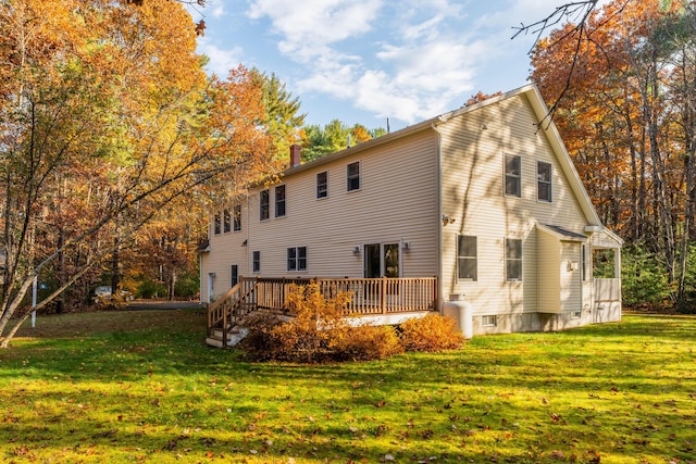 back of property featuring a lawn and a wooden deck