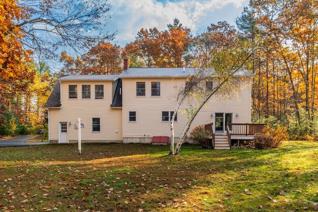 back of property with a yard and a deck