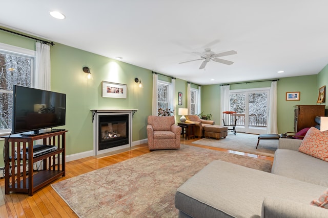 living room featuring ceiling fan, hardwood / wood-style floors, and a wealth of natural light