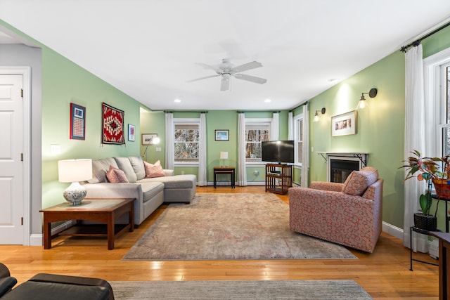 living room with light wood-type flooring and ceiling fan