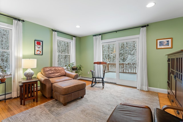 living area with a baseboard radiator and light wood-type flooring