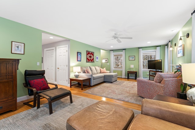 living room featuring light wood-type flooring and ceiling fan