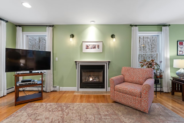 sitting room with a baseboard radiator and hardwood / wood-style flooring