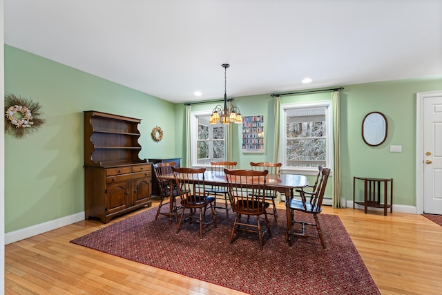 dining space with hardwood / wood-style flooring and a notable chandelier