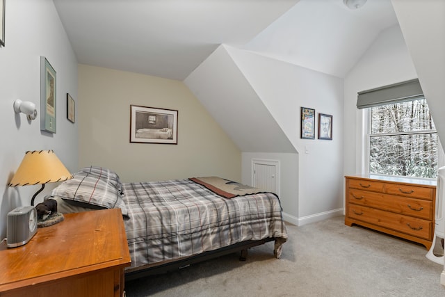 bedroom featuring light colored carpet and lofted ceiling