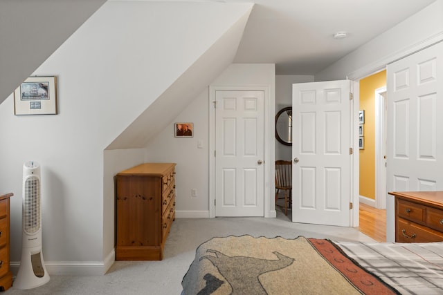 bedroom featuring light colored carpet and lofted ceiling