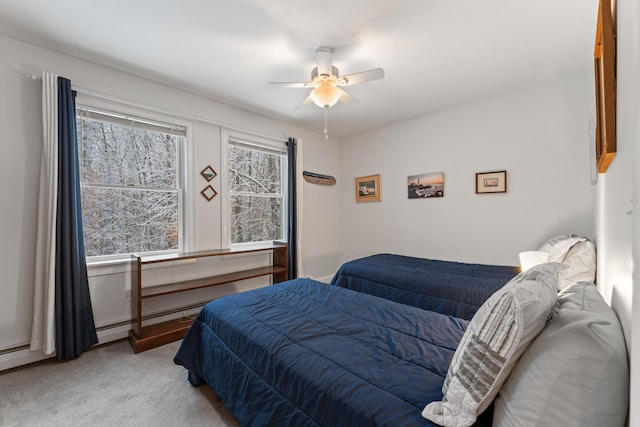 bedroom featuring light colored carpet, ceiling fan, and multiple windows