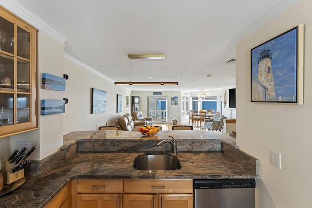 kitchen featuring crown molding, stainless steel dishwasher, dark stone countertops, and sink