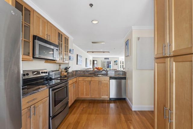 kitchen with sink, stainless steel appliances, light hardwood / wood-style flooring, kitchen peninsula, and crown molding