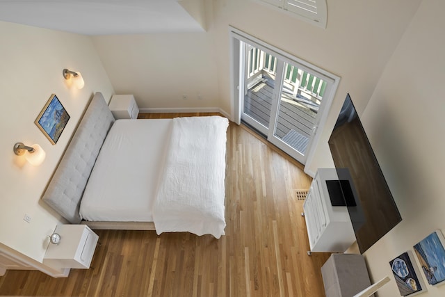 unfurnished bedroom featuring a high ceiling and hardwood / wood-style flooring