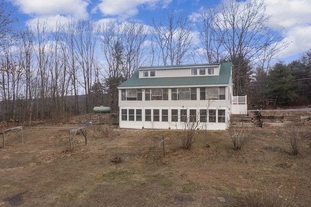 rear view of property featuring a sunroom