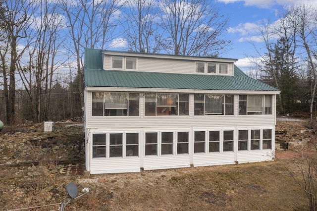 view of property exterior with a sunroom