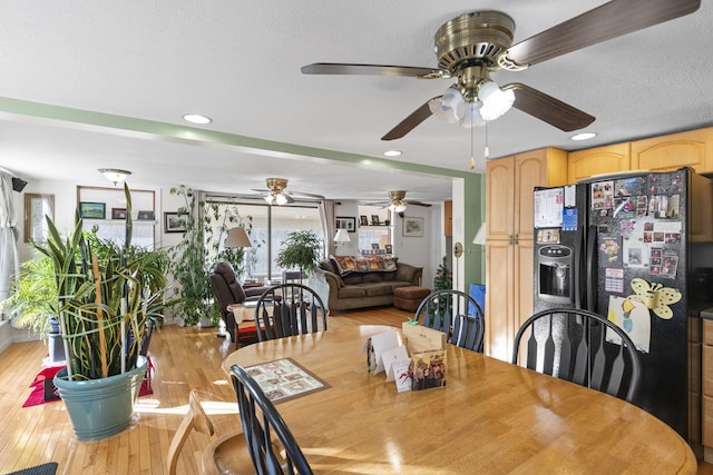 dining area featuring light wood-type flooring and a textured ceiling