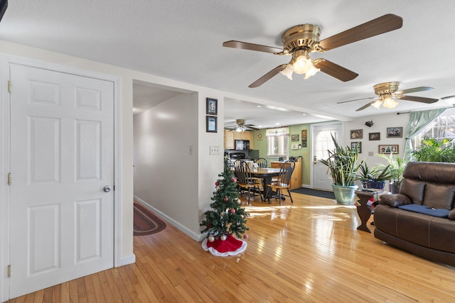 living room featuring light wood-type flooring and ceiling fan