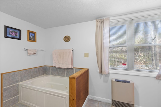 bathroom with tile patterned flooring, a bathtub, and a textured ceiling