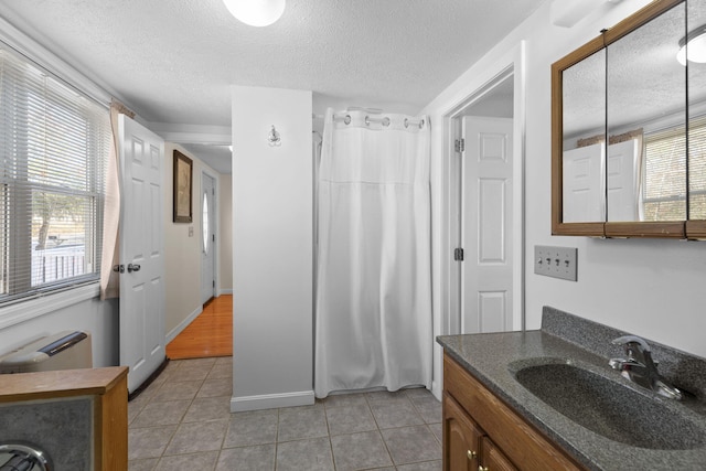 bathroom with tile patterned floors, curtained shower, vanity, and a textured ceiling