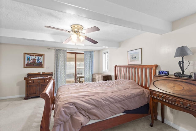 bedroom with a textured ceiling, light colored carpet, and ceiling fan