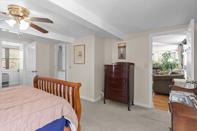 bedroom featuring beam ceiling, ceiling fan, and light carpet