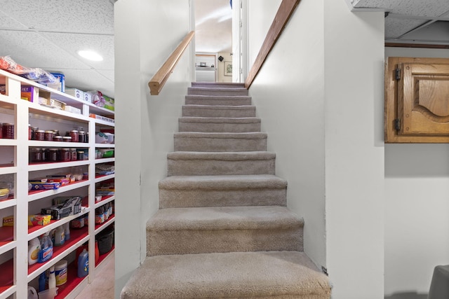 staircase featuring a drop ceiling