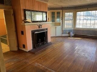 unfurnished living room featuring dark wood-type flooring and a baseboard radiator