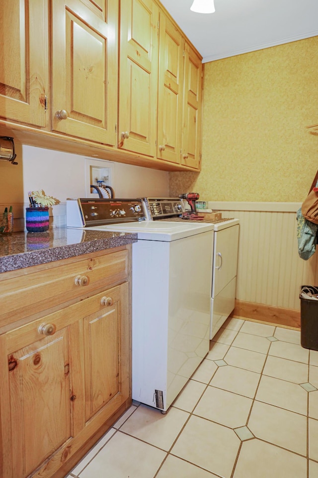 laundry room featuring washer and dryer, a wainscoted wall, cabinet space, and light tile patterned floors