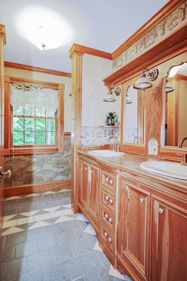 full bathroom with ornamental molding, wainscoting, a sink, and double vanity