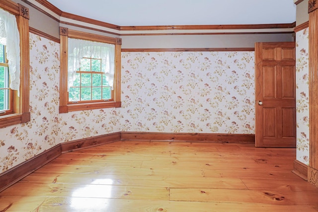 spare room with light wood-type flooring, baseboards, and wallpapered walls