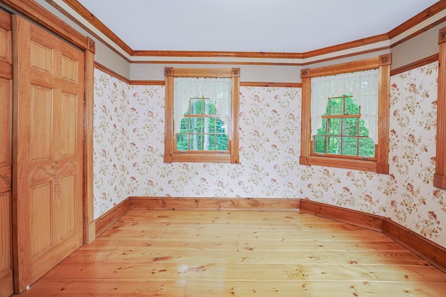 unfurnished room with baseboards, light wood finished floors, and wallpapered walls