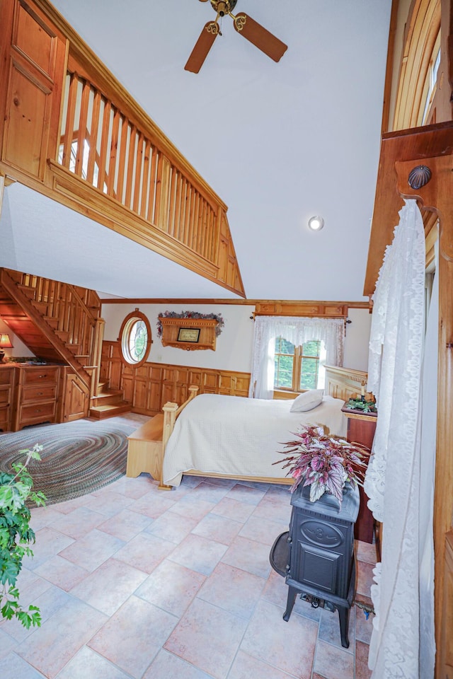 bedroom featuring a wainscoted wall, high vaulted ceiling, and crown molding