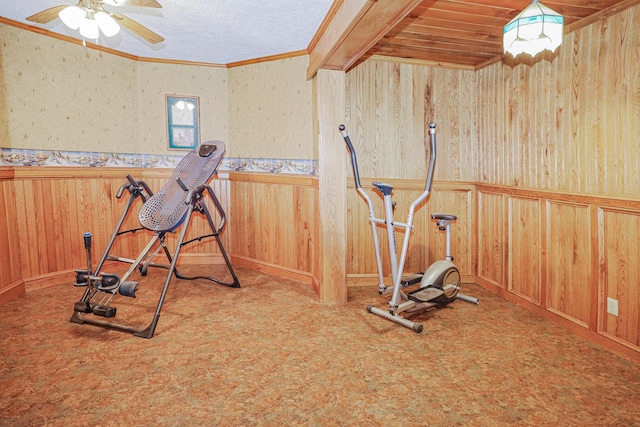 workout room with a wainscoted wall, crown molding, wooden walls, and carpet flooring