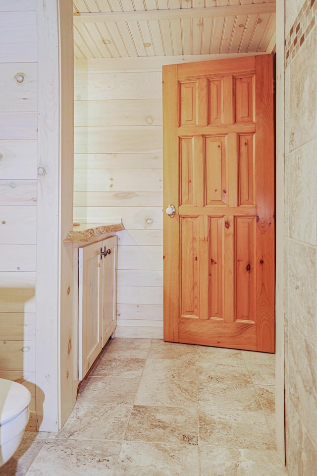 interior space featuring wooden ceiling and wooden walls