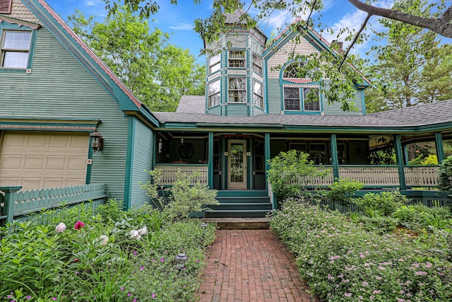 view of front facade featuring a garage, covered porch, a shingled roof, and a chimney