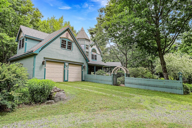 view of home's exterior with a yard, fence, a shingled roof, and a garage