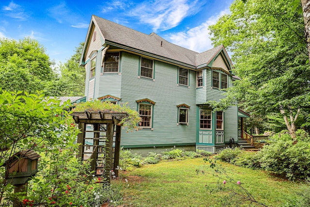 rear view of property with a shingled roof