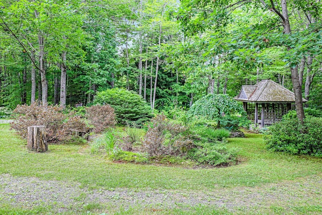 view of yard featuring a wooded view and a gazebo