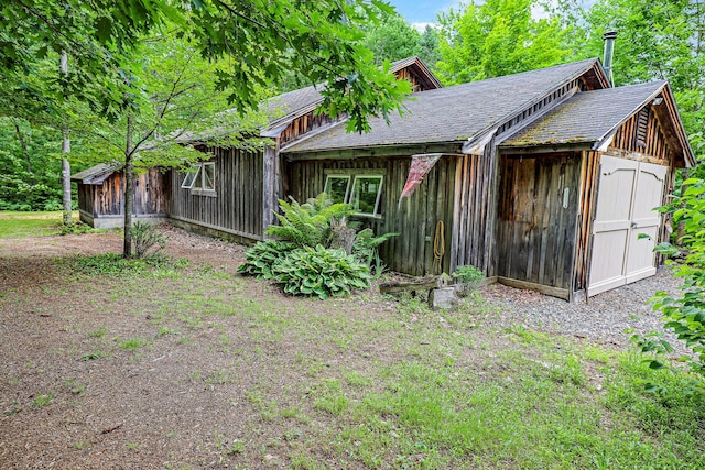 exterior space with roof with shingles and board and batten siding